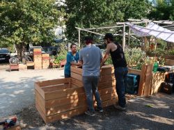 trois bénévoles autour du composteur en bois