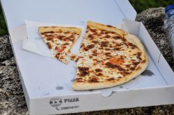 Part de pizza dans une boite en carton